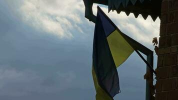 de ukrainska flagga fladdrar i de vind mot en molnig dyster himmel. video