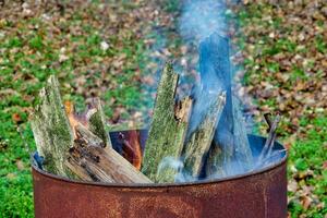 a fire pit with wood and smoke coming out of it photo