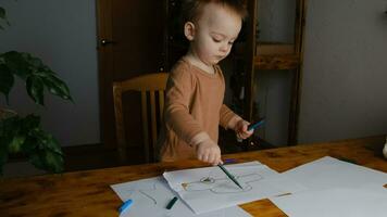 caucasien bambin garçon apprend à dessiner avec feutre des stylos. premier bébé dessins, video