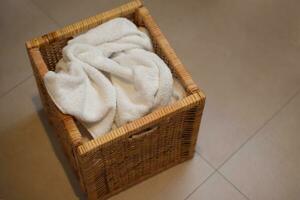 Dirty cloth towels in wooden box in bathroom, household chore photo