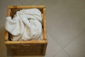 Dirty cloth towels in wooden box in bathroom, household chore photo