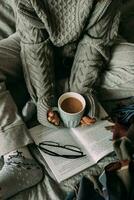 Winter still life concept. Young girl holding cacao mug, reading book. Season holiday, hygge concept photo
