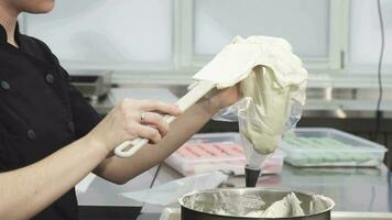 Cropped shot of a confectioner putting sour cream into pastry bag video