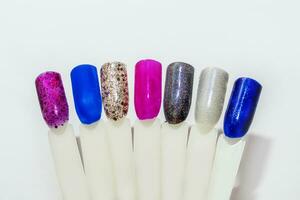 Palette of nail designs, testers of multicolored polishes on flat nails photo