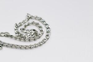 Different silver metal chains on a light background. photo