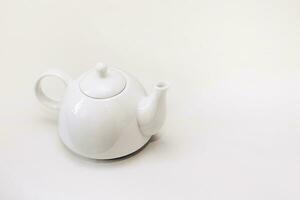 White ceramic teapot infuser on white background photo