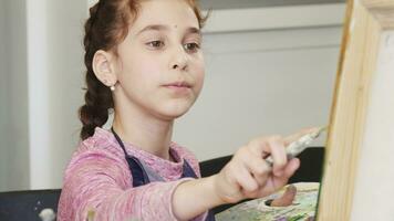 Pretty little girl holding pallette painting a picture video