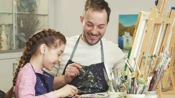 Father and daughter enjoying painting together high fiving at art studio video