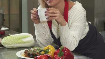 Happy mature woman smiling having coffee resting after cooking at the kitchen video