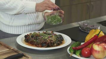 tondu fermer en haut de une femme garnir délicieux plat avec légumes verts cuisine à Accueil video