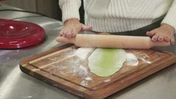 ritagliata tiro di un' donna rotolamento su verde Impasto con erbe aromatiche per pasta video