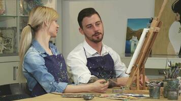 liebend jung Paar genießen Arbeiten auf ein Gemälde beim das Kunst Studio zusammen video