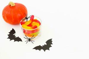 Pumpkin with jelly worms on a white table, Halloween concept photo