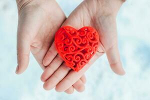 decorativo rojo corazón para San Valentín día en manos foto