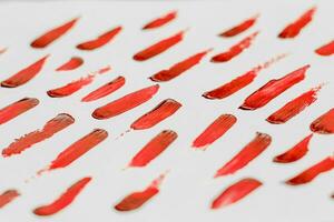 Smears of red cosmetic lipstick on a light background. photo