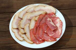 Sliced pieces of spicy lard and meat on a plate photo