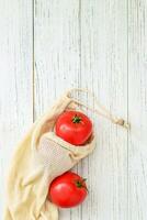 Reusable eco bags for shopping with tomato, replacing plastic bags photo