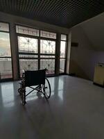 el silla de ruedas en el medio de un vacío corredor en el hospital foto