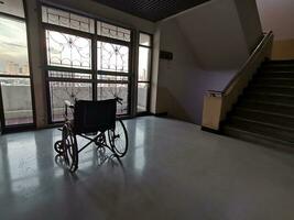 el silla de ruedas en el medio de un vacío corredor en el hospital foto