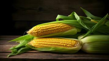 Fresh Yellow Corn on the Cob with Green Leaves on Dark Wooden Table photo