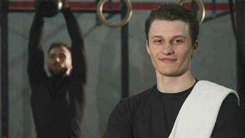 alegre joven deportista sonriente a el cámara posando a el gimnasio video