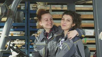 Two cheerful female factory workers hugging smiling happily to the camera video