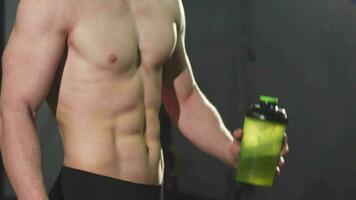 Cropped shot of a shirtless man with perfect abs holding water showing thumbs up video