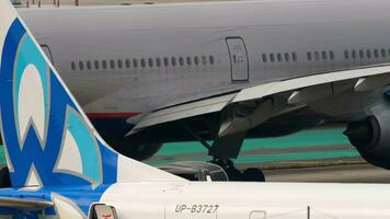 PHUKET, THAILAND FEBRUARY 25, 2023 Boeing 777 of Aeroflot taxiing at Phuket airport, medium shot. Foreground of Boeing 737 MAX 9, UPB3727 SCAT Airlines, tail section video