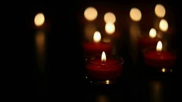 Burning candles on dark surface. Many burning candles with shallow depth of field. video