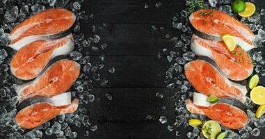 Fresh salmon steaks on ice, on black background. Top view. Copy space photo