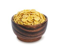 Corn flakes in wooden bowl isolated on white background photo