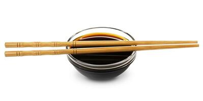 Soy sauce and chopsticks on white background photo