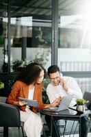 Two business workers talking on the smartphone and using laptop at the modern office. photo