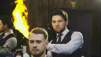 Professional barber working burning fire hair treatment on his client video