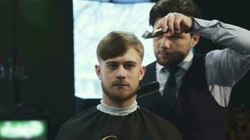 Handsome young man getting a haircut at the barbershop video