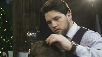 Professional barber spraying hair of his client while styling video