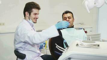 professionale dentista dando un' specchio per il suo paziente dopo dentale trattamento video