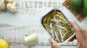 open blikje sardines op witte tegels achtergrond. video