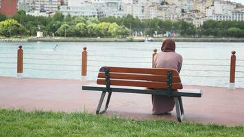 Unhappy girl sitting at bench . video