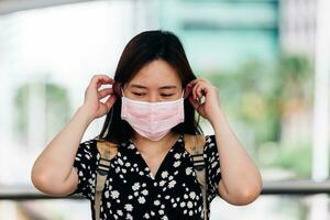 asiático mujer vistiendo cara máscara a proteger desde influenza virus foto