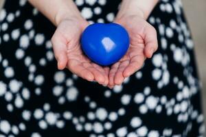 azul corazón en el manos de un mujer en un polca punto vestir foto