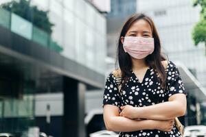 asiático mujer vistiendo cara máscara a proteger desde influenza virus foto