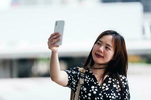 Portrait of thai adult beautiful girl using her smart phone Selfie photo