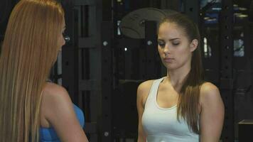 Beautiful young woman working out with personal trainer at the gym video