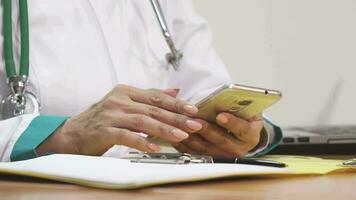 beskurna stänga upp av en kvinna läkare använder sig av smart telefon skrivning anteckningar video