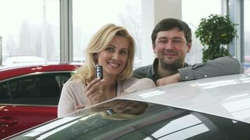 lindo feliz maduro casal posando perto seus Novo auto segurando carro chaves video