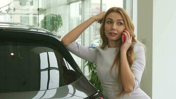 magnifique femme parlant sur le téléphone à le voiture concession salle d'exposition video