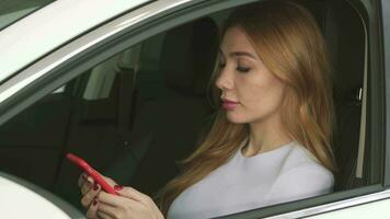 magnifique Jeune femme en utilisant intelligent téléphone séance dans sa voiture video
