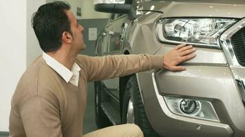 The business man sitted by the car shows the keys and strokes it by hand video