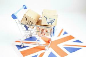 Online shopping, Shopping cart box on United Kingdom flag, import export, finance commerce. photo